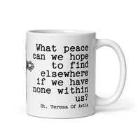White mug with black text quote by St. Teresa of Avila on a white background