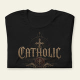 Folded black t-shirt with 'Catholic' design